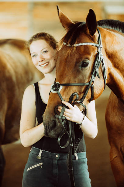 istock Woman hugging brown horse in stable 944206828