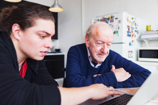 Teaching father how to operate a brand new laptop.