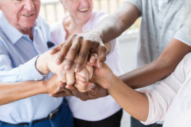 istock Group of seniors hold and stack hands on front porch 944221238