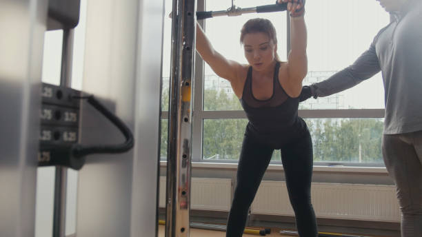 istock Attractive woman doing gym with personal instructor 944222220
