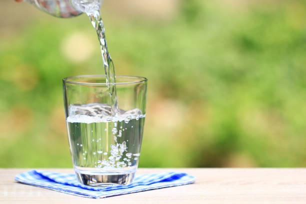 istock Closeup Glass of water on table nature background 944228954