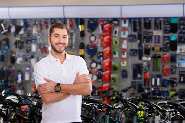 istock confident handsome young manager standing with crossed arms and smiling at camera in bicycle shop 944229848