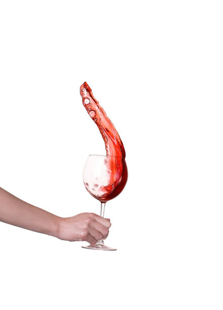 Red wine splashing from glass, isolated on white background