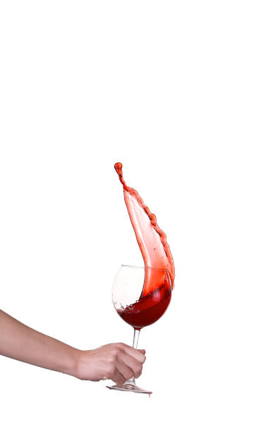 Red wine splashing from glass, isolated on white background