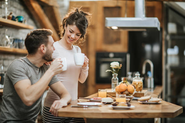 istock Young happy couple talking while drinking coffee in the morning. 944258670
