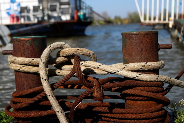 толстые лодочных канатов привязаны к старой ржавой боллард - moored nautical vessel tied knot sailboat стоковые фото и изображения