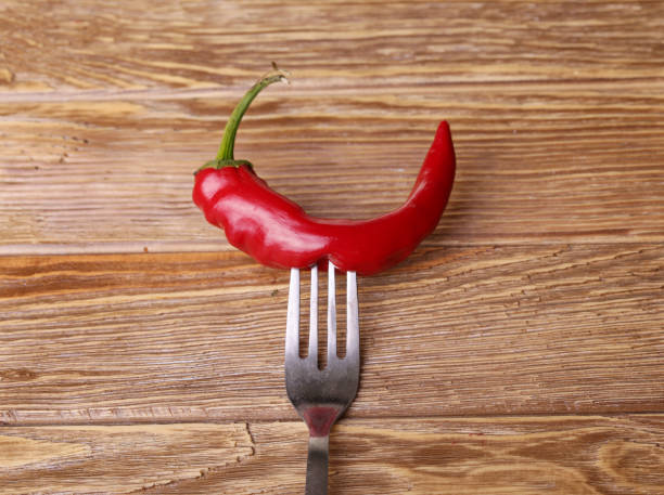 istock Chilli peppers and wood texture , background. 944260898