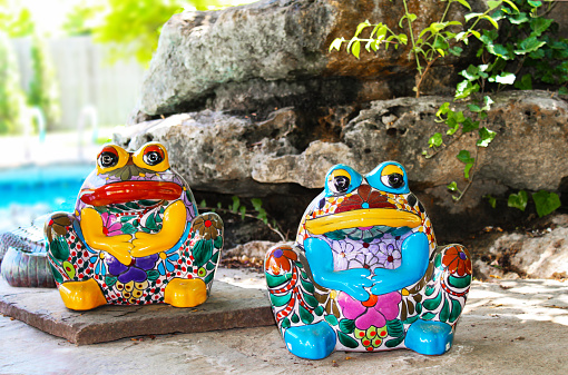 Dos brillantemente colorean y decoración sit ranas de cerámica por paisajismo piscina las rocas photo