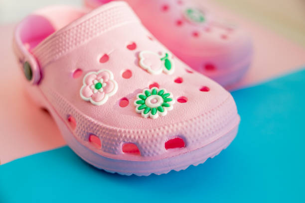 Colorful children's rubber sandals isolated on the blue background. pink rubber shoes.Children's shoes Colorful children's rubber sandals isolated.pink rubber shoes isolated crocodile stock pictures, royalty-free photos & images
