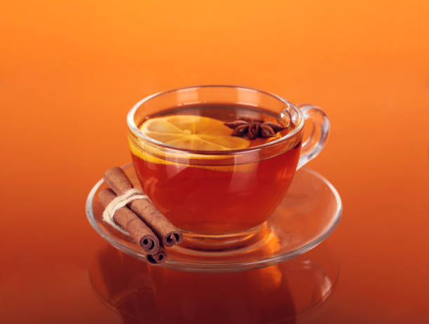 istock Cup of tea on glass with orange background 944278626