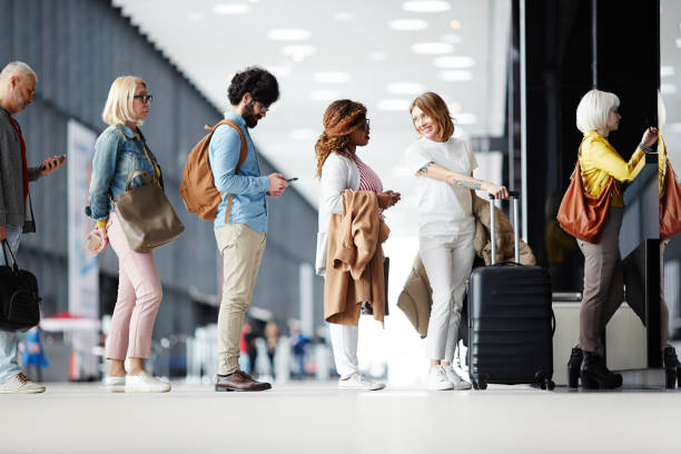 Queue of passengers Several passengers standing in queue while waiting for check-in registration before flight waiting in line stock pictures, royalty-free photos & images