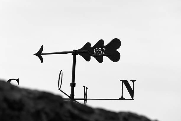 Iron weather vane as a compass with arrow and year