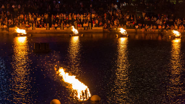 Crowds enjoy the glow of the WaterFire display Crowds sit mesmerized by the wood burning torches. providence rhode island stock pictures, royalty-free photos & images