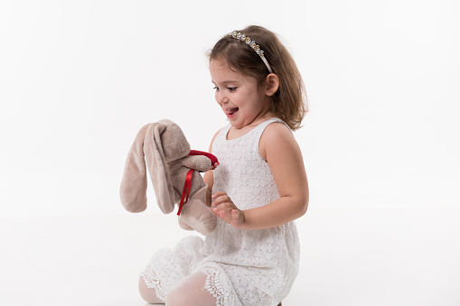Cute little girl playin with toy on a white background
