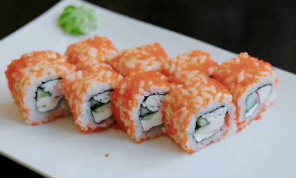 istock Close-up rolls with caviar with pickled ginger and wasabi on a white rectangular plate. 944293852