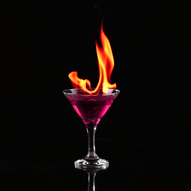 brennende alkoholische getränke mit eiswürfeln, auf schwarzem hintergrund - martini brand vermouth stock-fotos und bilder