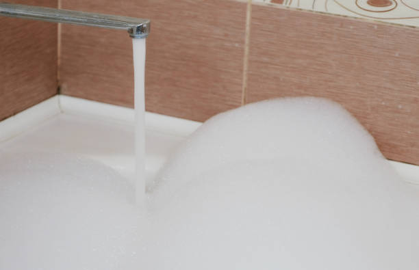 istock Water flows in a bubble bath. A lot of white foam. Closeup. 944300024