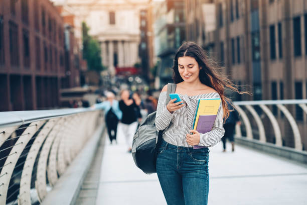istock University student with smart phone and textbooks 944300664
