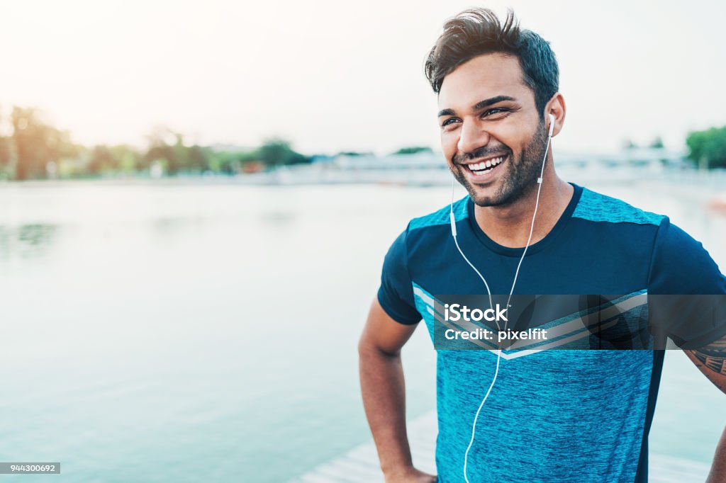 Cheerful young athlete outdoors by the river Portrait of a smiling young Middle-Eastern ethnicity athlete Men Stock Photo