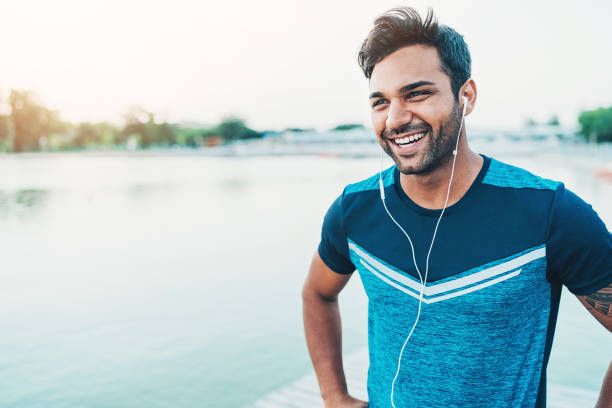 Cheerful young athlete outdoors by the river Portrait of a smiling young Middle-Eastern ethnicity athlete indian ethnicity lifestyle stock pictures, royalty-free photos & images