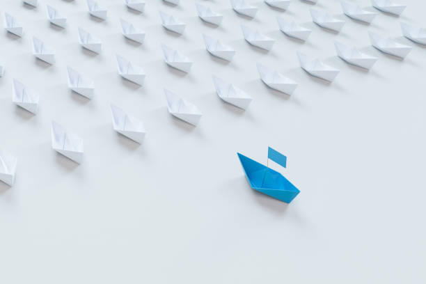 istock Leadership concept with red paper ship leading among white on white background.3d rendering. 944311508
