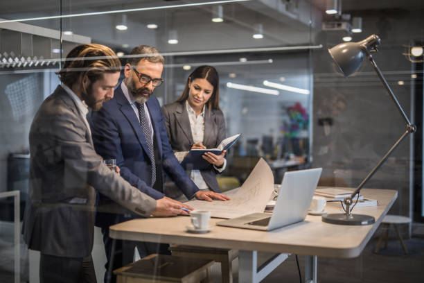 istock Team of entrepreneurs cooperating while working on blueprints in the office. 944315174
