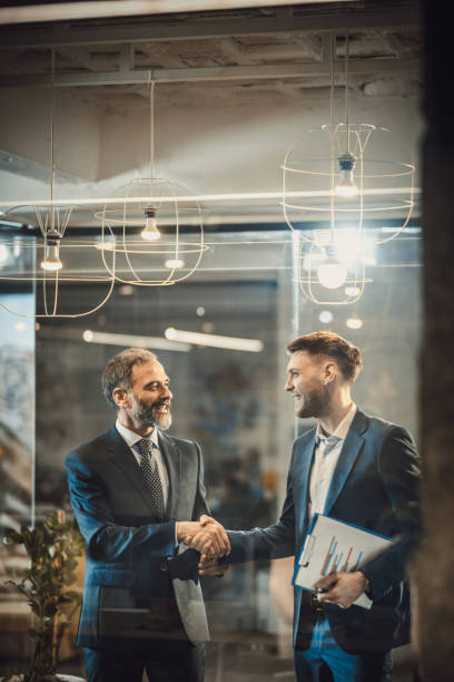 Two happy businessmen shaking hands in the office.
