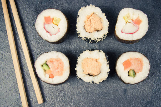 istock Various kinds of sushi on the dark background. 944328998