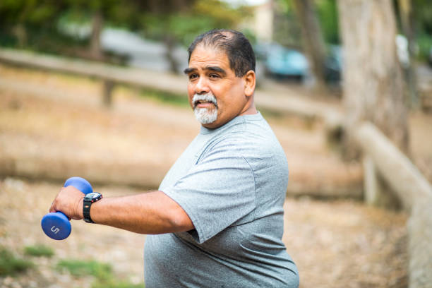 Senior Mexican Man Working Out Lifting Weights A senior mexican man working out lifting weights fat mexican man pictures stock pictures, royalty-free photos & images