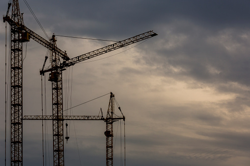 Construction site with cranes and dramatic sky