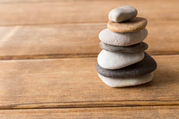 istock Pyramid of sea pebbles on a wooden table 944346750