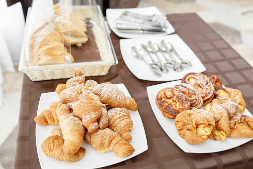Fresh croissants on white plate. French traditional pastry. Breakfast in hotel smorgasbord