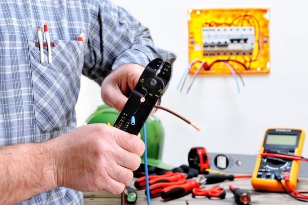 Electrician technician at work on a residential electric system Technical electrician to work in a residential electrical system, stripping the wire cable tester stock pictures, royalty-free photos & images