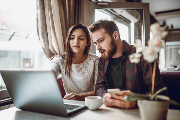 istock Cute Young Couple Drinking Coffee and Making Video Conference 944352754