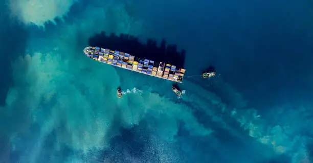 Aerial shoot of a cargo ship mooring in a harbour