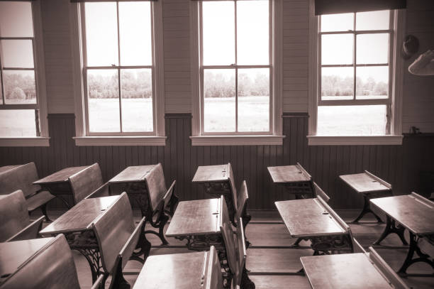 istock Early 1900's classroom scene with desks in sepia 944364724