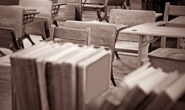istock Early 1900's classroom scene with desks in sepia 944364798