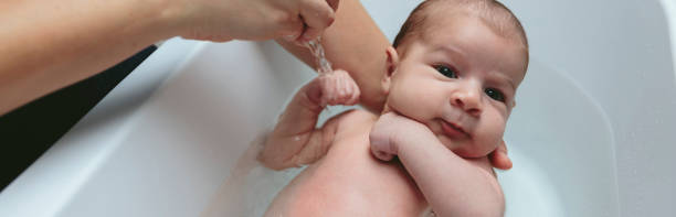 istock Newborn in the bathtub held by her mother 944368824