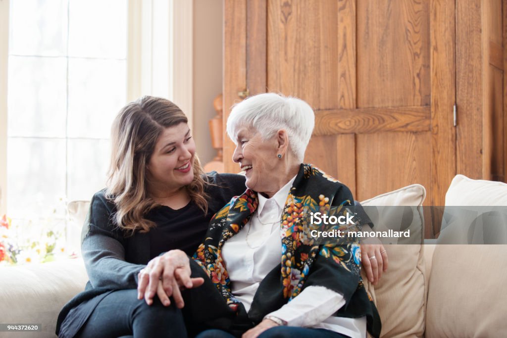Senior woman celebrate mother's day with her family Four generation family take time together for the mother's day. In this photo the grandmother talk with her granddaughter in the living room with happiness. Photo was taken in Quebec Canada. Senior Adult Stock Photo