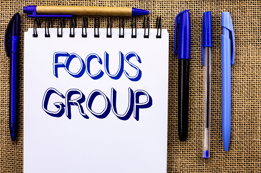 Writing note showing  Focus Group. Business photo showcasing Interactive Concentrating Planning Conference Survey Focused written Notebook Book the jute background Pens next to it.