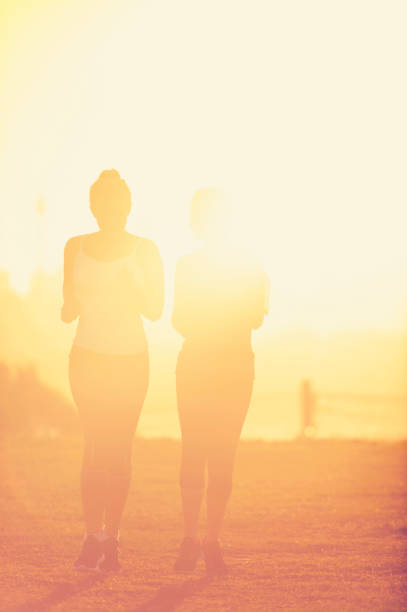istock 2 women running in the park at sunset. 944386256