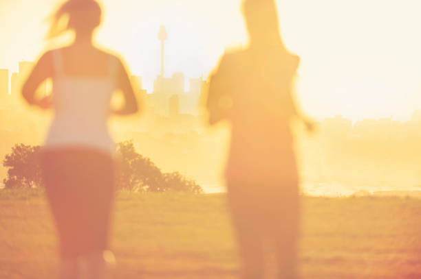 istock 2 women running in the park at sunset. . 944386272