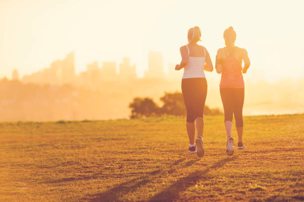 istock 2 women running in the park at sunset. 944386280