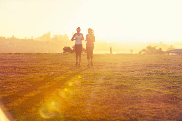 istock 2 women running in the park at sunset. 944386290
