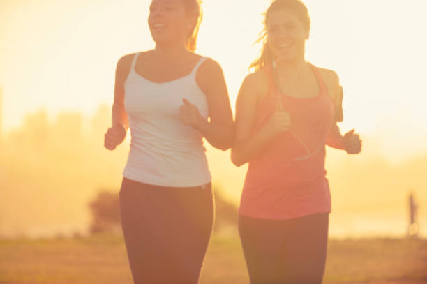 istock 2 women running in the park at sunset. 944386294