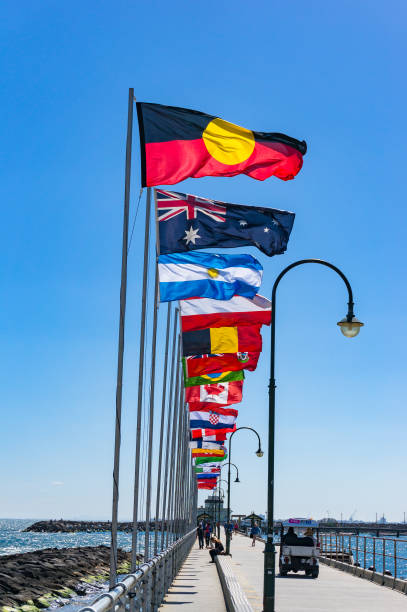 st kilda pier con filas de banderas nacionales con la bandera aborigen australiana - ariel cisjordania fotografías e imágenes de stock