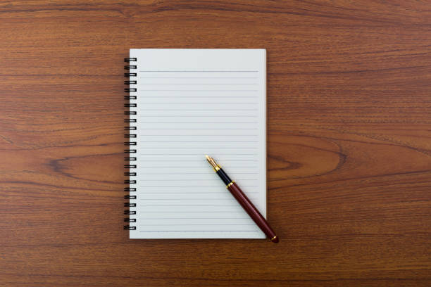 istock Fountain pen or ink pen with notebook paper on wooden working table with copy space, office desk concept. top view. 944401682