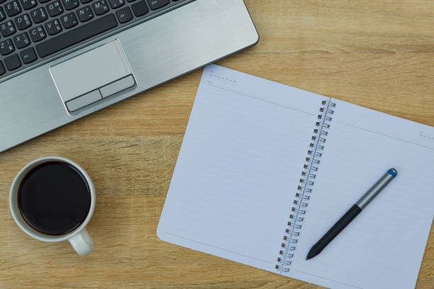 istock Laptop computer or notebook, note and cup of coffee on working table with copy space top view. 944401694