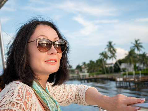 mature woman looking over the horizon with palm trees on the background