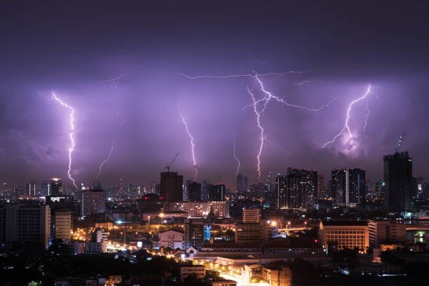 istock Lightning storm over city in purple light 944406728